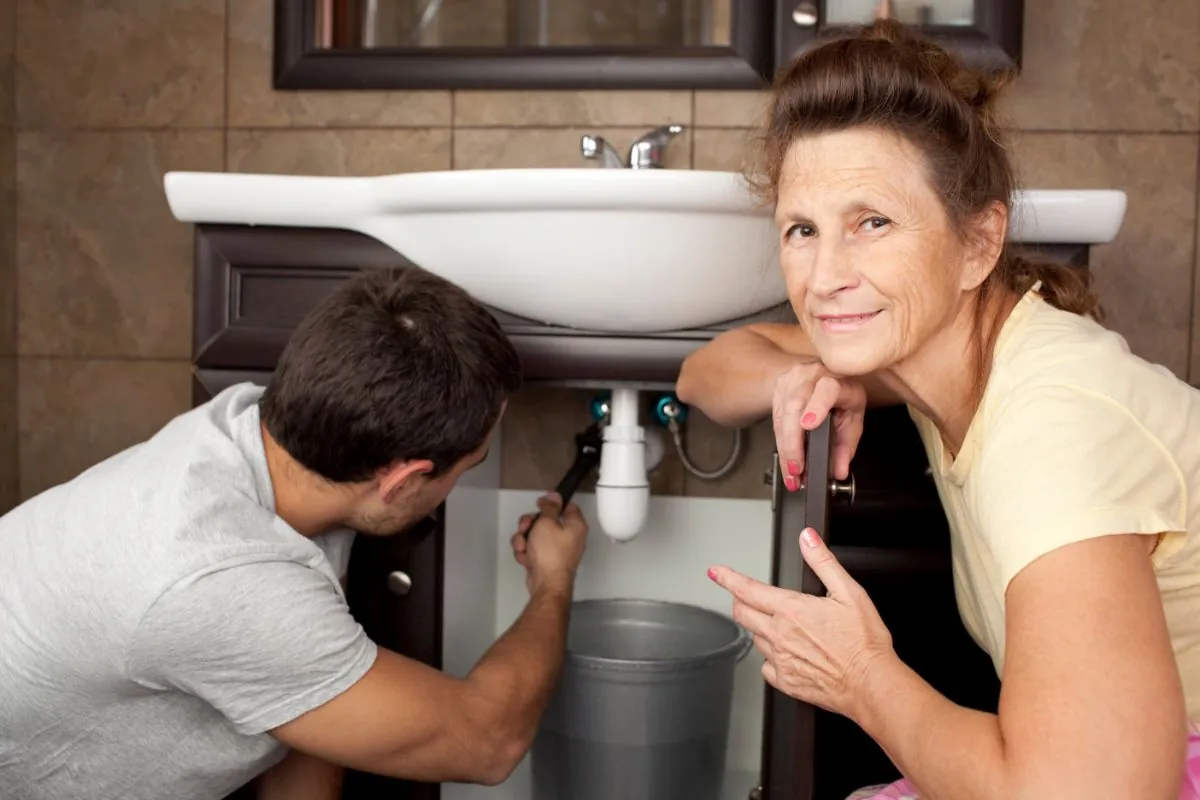 woman in bathroom with plumber